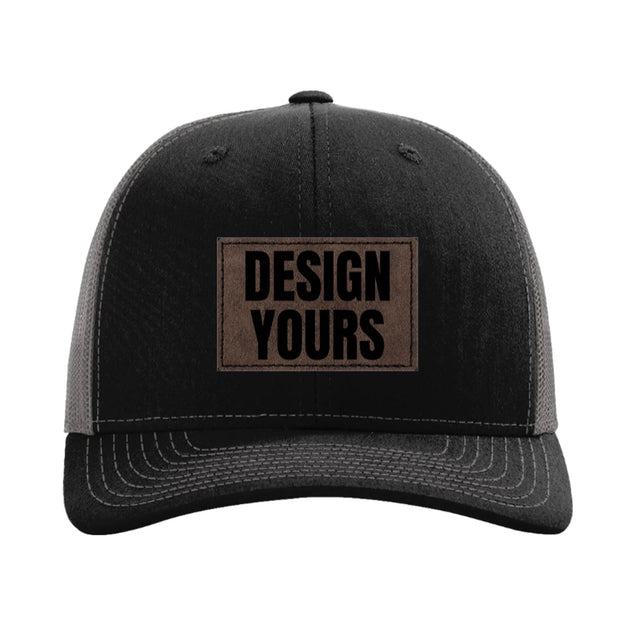 Custom laser-etched leatherette patch hat, black and charcoal Richardson 112, dark brown stitched patch reading Design Yours