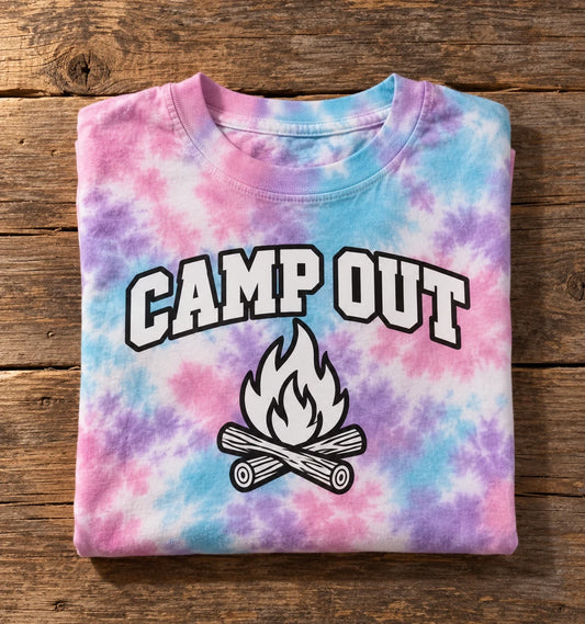 Custom Colortone youth tie-dye t-shirt in Cotton Candy with a full-color CAMP OUT campfire DTF print, folded on a wood table