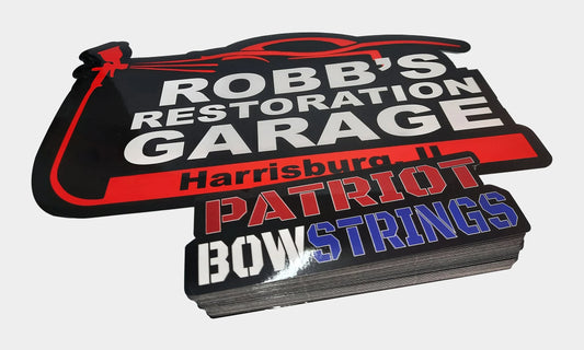 Custom die cut vinyl stickers cut in our shop - a restoration garage logo decal and a thick stack of red white and blue laminated stickers