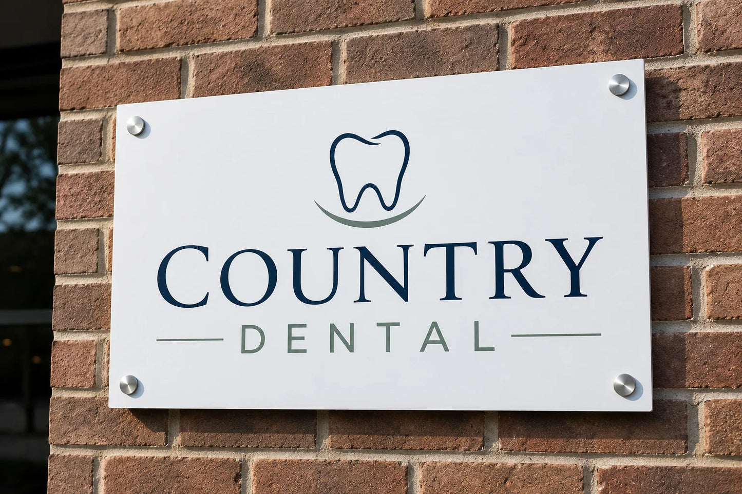 White aluminum composite wall sign for a dental office, mounted on a brick wall with silver standoff bolts