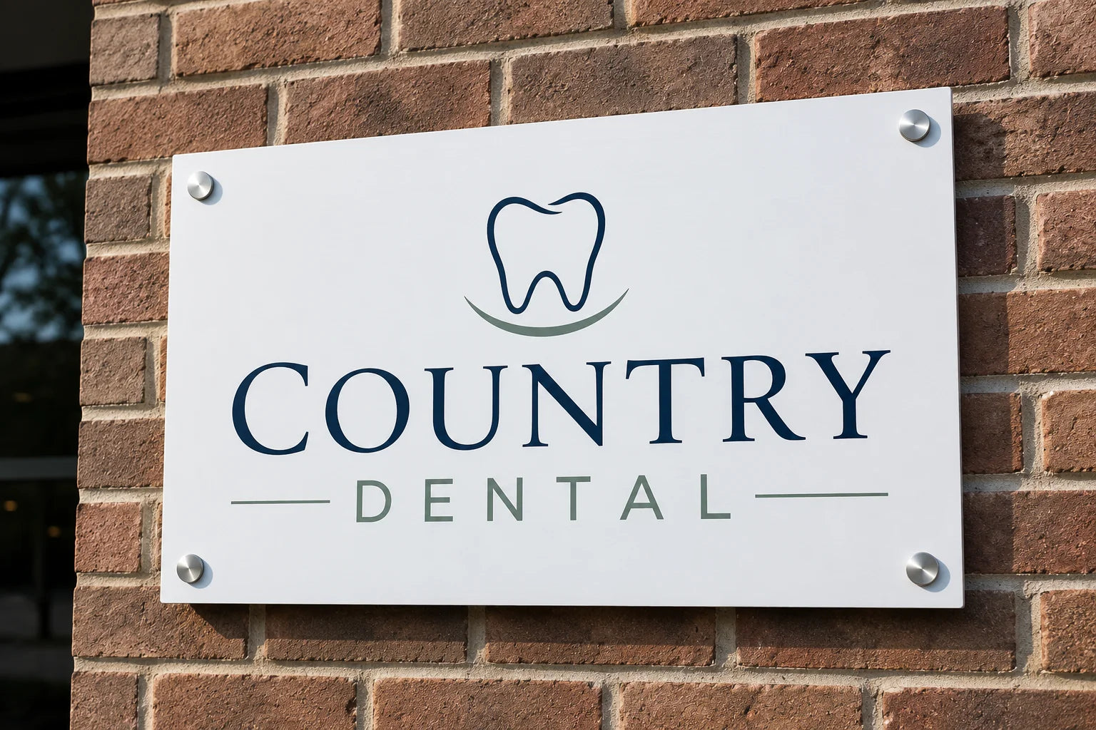 White aluminum composite wall sign for a dental office, mounted on a brick wall with silver standoff bolts