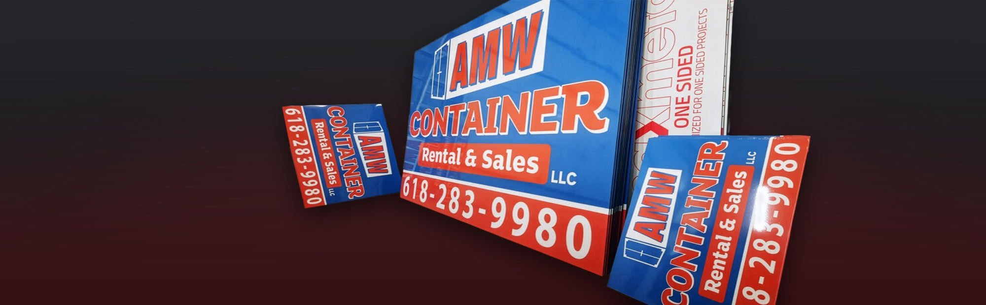 Fresh-printed AMW Container aluminum signs stacked in the Martin Graphics shop