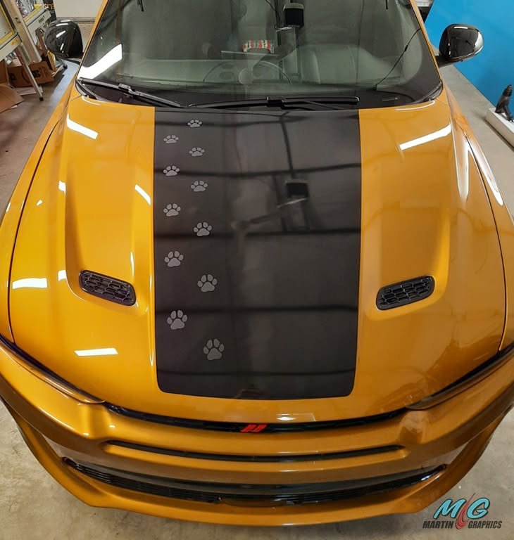 Matte black hood stripe with paw prints on an orange Charger